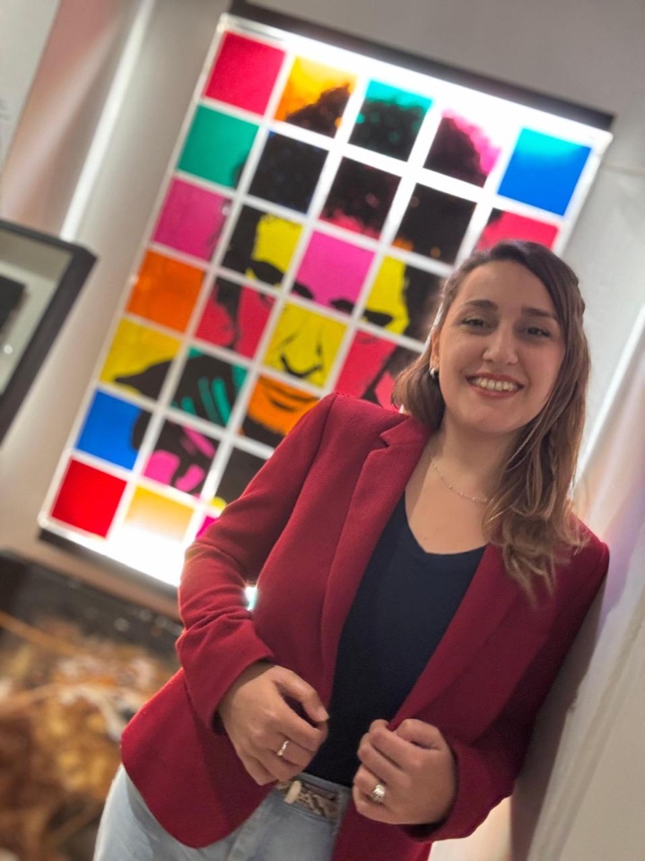 Antonella standing in front of a colorful artwork